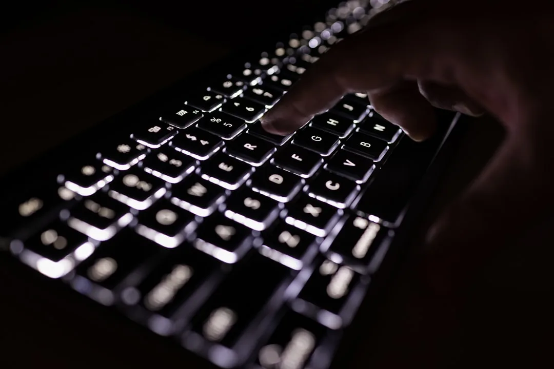Mão de profissional de clínica digitando em teclado retroiluminado, gerenciando agendamentos e no-shows para otimizar o tempo.